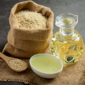 sesame oil and sesame seeds on dark background